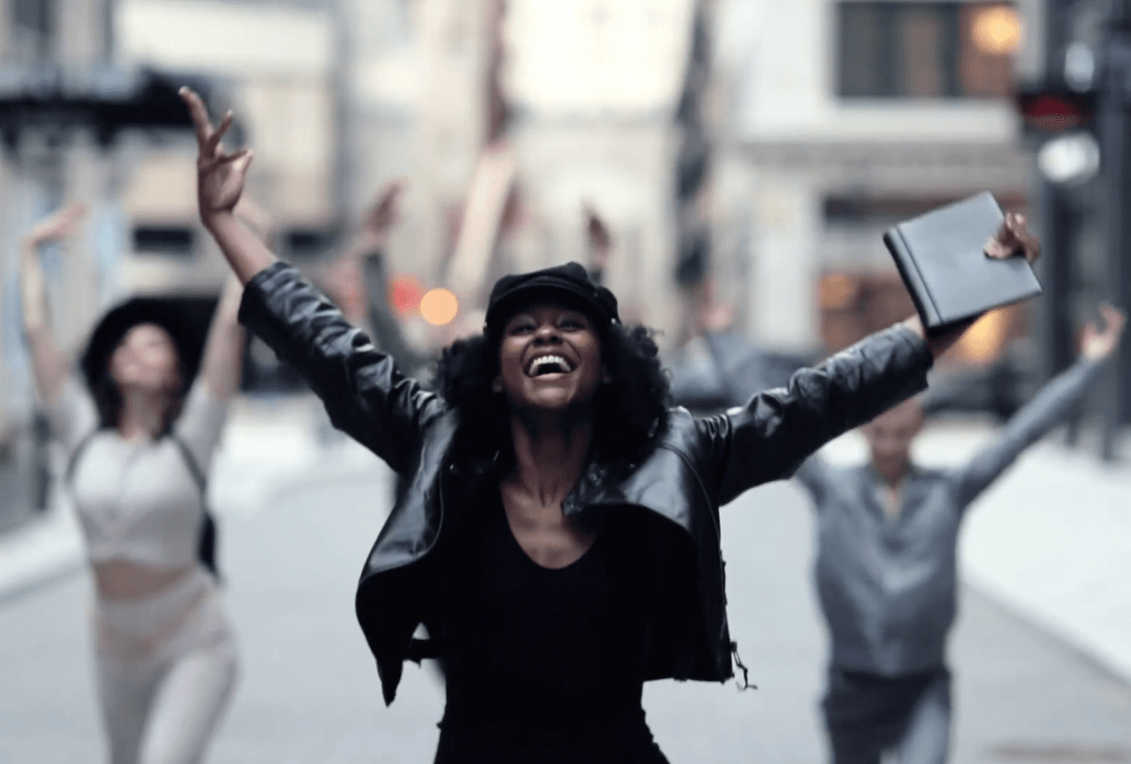 lifestyle image from video of women celebrating community and dancing in the streets outside of property