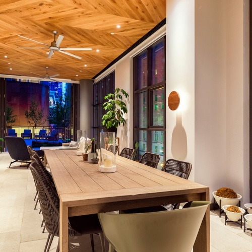 large wooden table with city views outside of large windows